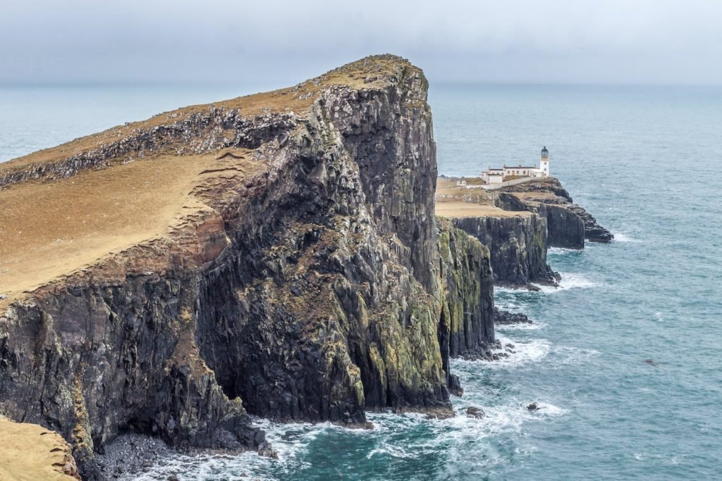 Lighthouse on Near Body of Water Between Rock Formation