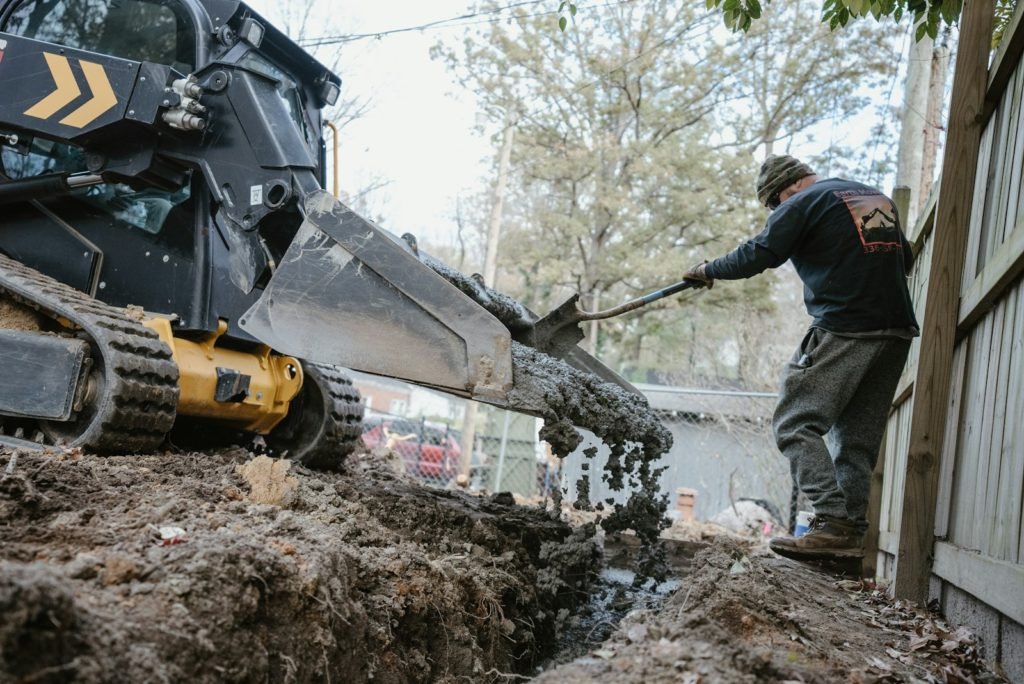 a man using a machine to lift a tree